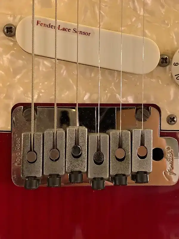 The Fender/Floyd Rose Locking Tremolo System. Note also the white shell pickguard and the Lace Sensor Red at the bridge