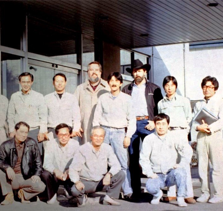 From Left to Right, Standing: Ace Nakata (Fujigen VP), Mr. Nakamura (Dept Foreman), Dan Smith, Makoto Sugimoto, Michael Stevens, Mr.Shimoda (Ensenada Paint Dept.), Mr.Hirabayashi (Guitar R&D and Regular Guitar Making). From Left to Right, Kneeling: Johnny Saitoh (Musician, He built the first Squier guitars), Mr.Takayama (Senior Factory Production Manager), Yoshimochi Kamijo (Fujigen President), Suzuki (Senior R&D Masterbuilder). 1988. Courtesy of M. N. Sugimoto