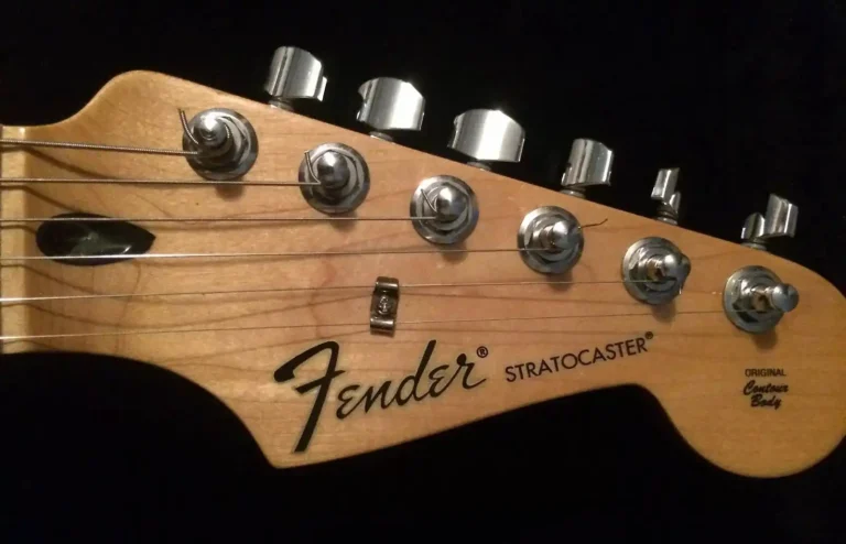 Headstock with black CBS-style logo and decals of the upgraded Standard Stratocaster, still featuring the black plastic truss-rod access
