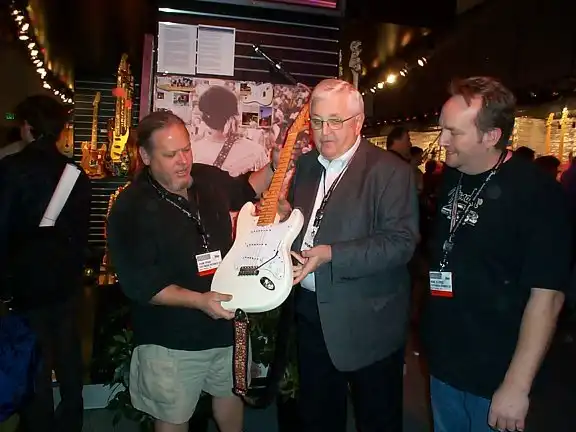 Bill Schultz and Mike Eldred present the guitar to John Page for the Fender Museum